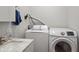 Bright laundry room features a modern washer and dryer set and a sink with a marble countertop at 1211 W 10Th St, Muncie, IN 47302
