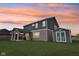 Evening backyard featuring a covered patio, storage shed, and a spacious lawn under a vibrant sky at 13163 N Departure W Blvd, Camby, IN 46113