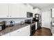 Kitchen featuring granite counters, stainless steel appliances, and white cabinets with dark accents at 13163 N Departure W Blvd, Camby, IN 46113