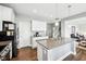 Bright kitchen features a center island with a granite countertop, stainless steel appliances, and wood flooring at 13163 N Departure W Blvd, Camby, IN 46113