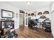 This home office space features hardwood floors, a desk, and shelving units with a variety of decor elements at 13163 N Departure W Blvd, Camby, IN 46113