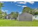 A gray sided garage sits near the house with a green lawn and cloudy sky at 1617 S Whittier Pl, Indianapolis, IN 46203