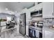 Modern kitchen featuring stainless steel appliances and views of the dining area at 1617 S Whittier Pl, Indianapolis, IN 46203