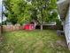 Backyard featuring a red shed, a mature tree, and a wood fence at 1653 Wade St, Indianapolis, IN 46203