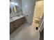 Bathroom featuring a double sink vanity, tile floor, modern lighting, and a separate toilet room at 1653 Wade St, Indianapolis, IN 46203