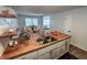 Bright kitchen with a stainless sink, wooden countertops, white cabinets, and an eat-in dining area at 1653 Wade St, Indianapolis, IN 46203