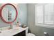 Well-lit powder room featuring a modern vanity with a round mirror and window with shutter blinds at 16732 Maraschino Dr, Noblesville, IN 46062