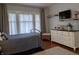 Cozy bedroom with a comfortable bed, dresser, and modern decor featuring light-filled windows and hardwood floors at 1728 Newton St, Columbus, IN 47201