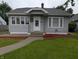 Inviting home exterior with gray siding, green lawn, and a welcoming front porch with a wreath at 1728 Newton St, Columbus, IN 47201