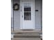 Close-up of a front door with glass panel, decorative wreath, and a mail slot at 1728 Newton St, Columbus, IN 47201