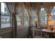 Bright sunroom with large windows, elegant curtains, a desk, and natural light at 1728 Newton St, Columbus, IN 47201