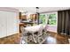 Dining area with a large table and views of the backyard, seamlessly connects to the kitchen area at 1926 Fairmont Ct, Indianapolis, IN 46229