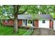 Charming one-story home featuring a brick facade, a well-manicured lawn, and mature trees providing ample shade at 1926 Fairmont Ct, Indianapolis, IN 46229