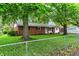 Inviting brick home surrounded by green lawn and mature trees, enhancing curb appeal at 1926 Fairmont Ct, Indianapolis, IN 46229