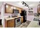 Kitchen featuring wooden cabinets, stainless steel oven, black refrigerator, and tiled flooring at 1926 Fairmont Ct, Indianapolis, IN 46229