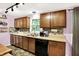 Bright kitchen with brown cabinets, double sink, stainless steel appliances, and a window view at 1926 Fairmont Ct, Indianapolis, IN 46229