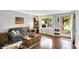 Bright living room featuring hardwood floors, a comfortable couch, and a large window with natural light at 1926 Fairmont Ct, Indianapolis, IN 46229