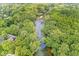 An aerial view of a river surrounded by lush green trees, with a home visible in the lower left corner at 20322 Wagon Trail Dr, Noblesville, IN 46060