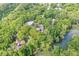 Aerial view of a private estate nestled among lush trees, featuring a pond and ample parking at 20322 Wagon Trail Dr, Noblesville, IN 46060