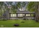 A house with a stone chimney, bay window, and a large backyard with a fire pit at 20322 Wagon Trail Dr, Noblesville, IN 46060