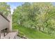 Spacious backyard with lush green lawn, mature trees, stone chimney, and inviting wooden deck overlooking the scene at 20322 Wagon Trail Dr, Noblesville, IN 46060