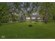 Expansive backyard featuring a stone fireplace and lush greenery, perfect for outdoor relaxation at 20322 Wagon Trail Dr, Noblesville, IN 46060