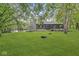 Spacious backyard with lush lawn, mature trees, and fire pit offers a peaceful retreat at 20322 Wagon Trail Dr, Noblesville, IN 46060
