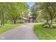 A two-story home with a stone chimney, bay window, and a large driveway with mature trees at 20322 Wagon Trail Dr, Noblesville, IN 46060