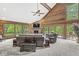 Cozy living room with wood-paneled walls, stone fireplace, high ceilings, and large windows showcasing the natural surroundings at 20322 Wagon Trail Dr, Noblesville, IN 46060