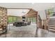 An open living room with fireplace, wood accents, and large windows providing scenic views and access to backyard deck at 20322 Wagon Trail Dr, Noblesville, IN 46060