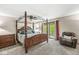 Comfortable main bedroom with a four-poster bed, outdoor access, and plush carpeting at 20322 Wagon Trail Dr, Noblesville, IN 46060
