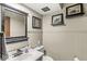 Elegant powder room featuring beadboard paneling, black framed mirror and decor, and neutral tones at 20322 Wagon Trail Dr, Noblesville, IN 46060