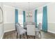 Bright dining room featuring a glass table, upholstered chairs, and stylish turquoise curtains at 2260 Santa Fe Dr, Greenfield, IN 46140