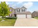 Charming two-story home with a two car garage, complemented by a beautiful green lawn and vibrant tree at 2260 Santa Fe Dr, Greenfield, IN 46140