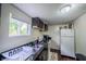 Efficient kitchen with dark cabinetry, granite countertops, and essential appliances at 2358 Hovey St, Indianapolis, IN 46218