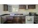 Functional kitchen with dark wood cabinets, granite countertops, and modern appliances at 2358 Hovey St, Indianapolis, IN 46218