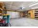 Bright garage featuring storage, a work bench, and a metal roll-up door at 2509 Cedarmill Dr, Franklin, IN 46131