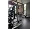 Home gym featuring black rubber flooring, red brick accent wall, and weightlifting equipment by windows at 2509 Cedarmill Dr, Franklin, IN 46131