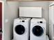 Functional laundry room with modern washer and dryer units, and overhead storage cabinets at 2612 E Northgate St, Indianapolis, IN 46220