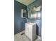 Stylish bathroom with navy walls, updated vanity, decorative lighting, and a marble-look floor at 2823 Boulevard Pl, Indianapolis, IN 46208