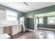 View of a kitchen featuring green walls, white cabinets, stainless steel appliances, and hardwood floors at 2823 Boulevard Pl, Indianapolis, IN 46208