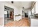 View of the kitchen leading into the living area, featuring wood floors and white cabinets at 2840 Denison St, Indianapolis, IN 46241