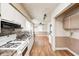Well-lit kitchen with white cabinets, appliances, and view into adjoining room at 2840 Denison St, Indianapolis, IN 46241