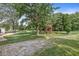 Large, well-maintained backyard with a wooden playset, mature trees, and an outdoor seating area for relaxation at 3030 E 236Th St, Cicero, IN 46034