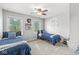 Cozy bedroom featuring two twin beds, ceiling fan, matching blue bedding, and picturesque window views at 3030 E 236Th St, Cicero, IN 46034