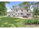 Rear view of a white two-story home with a patio seating area and well-maintained lawn in a serene backyard setting at 3030 E 236Th St, Cicero, IN 46034