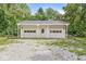 Two-car garage with white doors and gravel driveway, providing ample parking and storage space at 3030 E 236Th St, Cicero, IN 46034