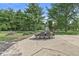 Outdoor patio area featuring a dining table set on a spacious concrete slab surrounded by a large, grassy yard and mature trees at 3030 E 236Th St, Cicero, IN 46034