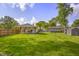 Lush backyard featuring a covered porch, well-maintained lawn, and the detached two-car garage in the distance at 3113 Westenedge Dr, Columbus, IN 47203