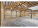 Inside the oversized two-car garage, showcasing the ample space, wood beams, lighting, and electric garage door openers at 3113 Westenedge Dr, Columbus, IN 47203